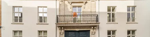 gerenoveerd statig gebouw met witte voorgevel en balkon in het centrum van Tienen